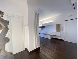 Ein modernes Interieur mit Holzboden, weißen Wänden und einer integrierten Küchenzeile mit Arbeitsplatte und Spüle.