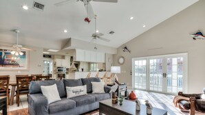 A spacious living room with a grey sofa, wooden coffee table, and a dining area with wooden chairs. - House at Bonita (Bonita Springs)