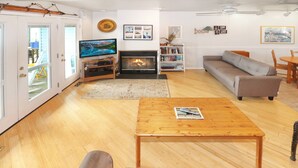 Un salon avec une cheminée, un téléviseur, un canapé et une table basse.