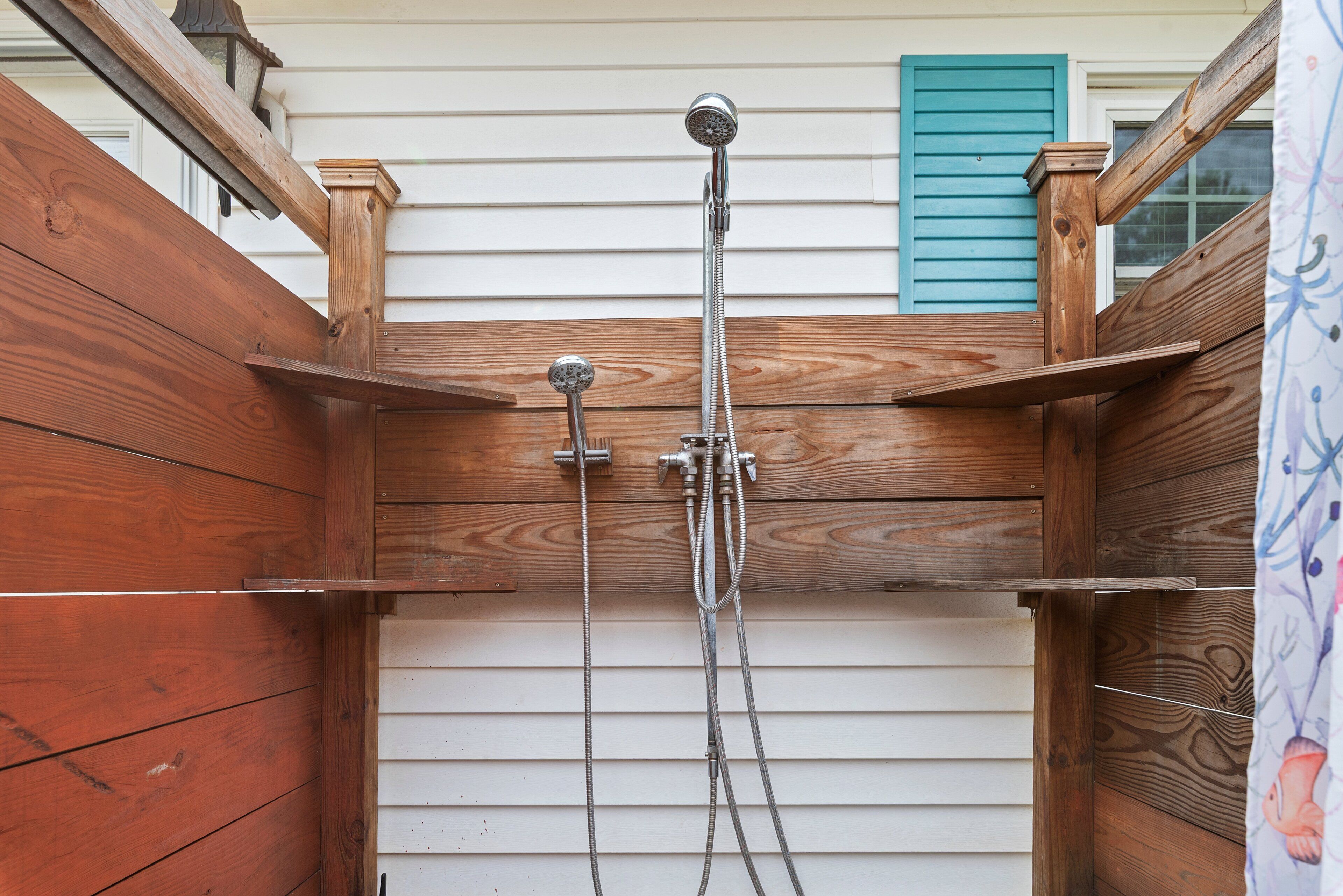 Cabina de ducha de madera con ducha y manguera.