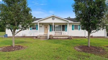 A single-story house with a front porch, a mailbox, and a lawn.