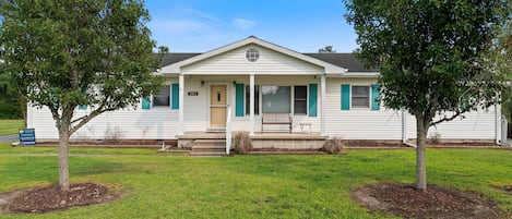 A single-story house with a front porch, a mailbox, and a lawn.
