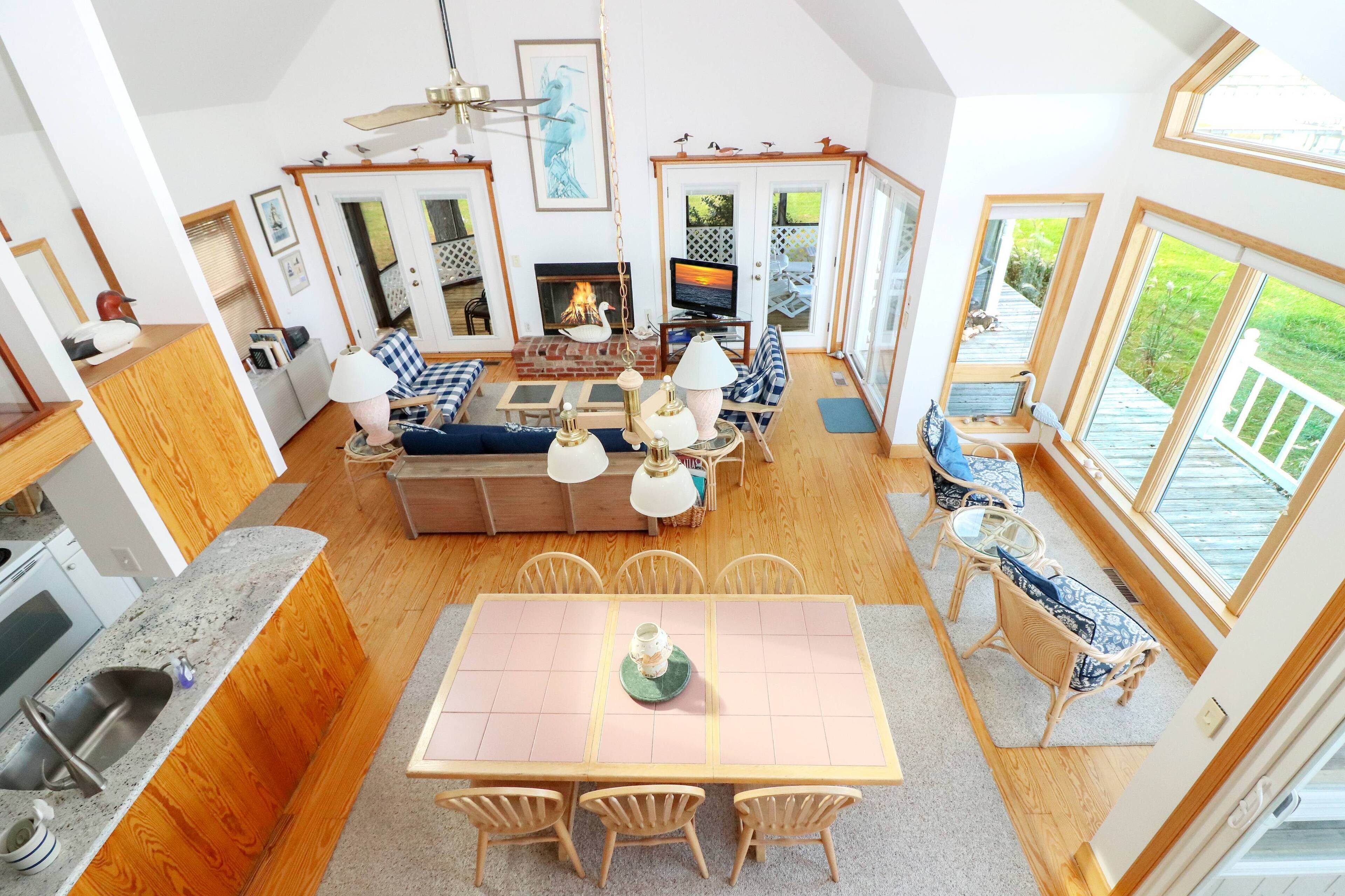 Amplia sala de estar con chimenea, televisor y una mesa de comedor con sillas.