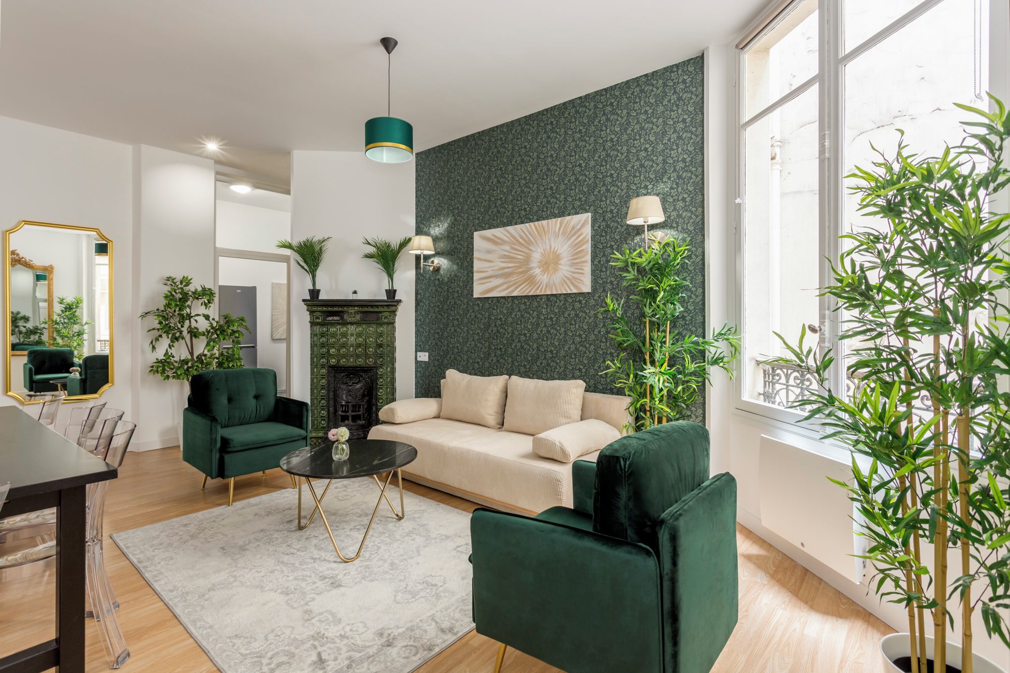A modern living room with a green sofa, a fireplace, and a large window.