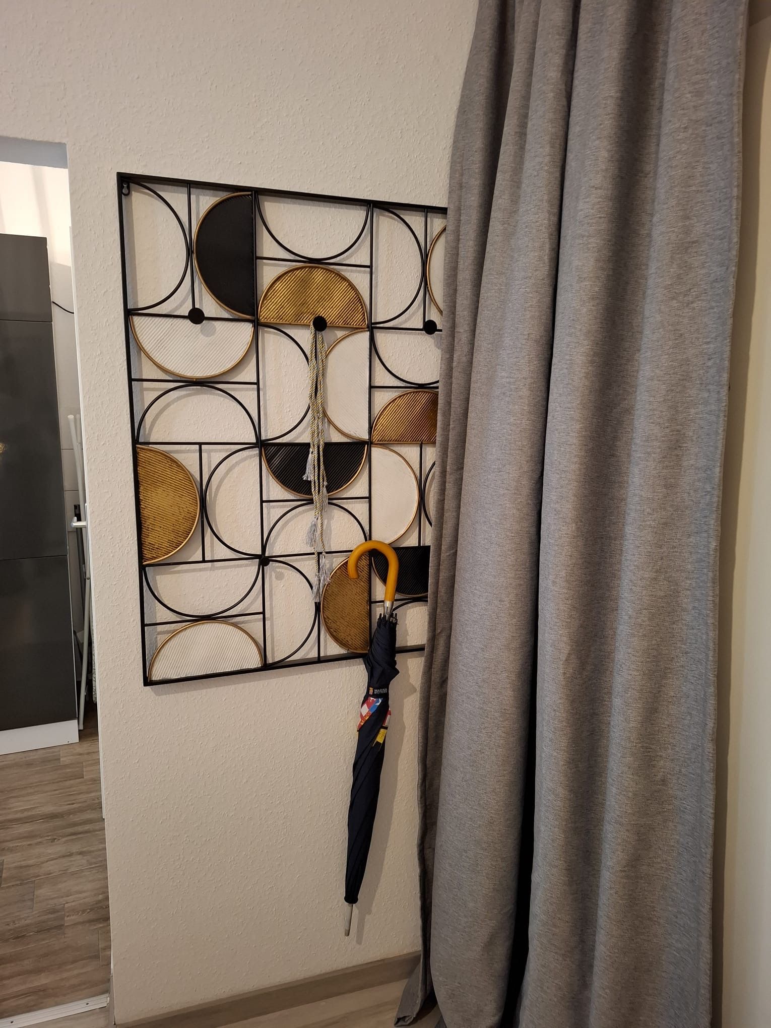 Eine Wand mit einem geometrischen Muster und einem hängenden Regenschirm.
