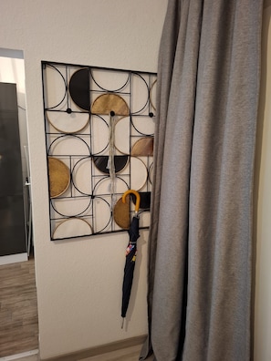 A wall with a geometric pattern and a hanging umbrella.