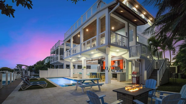 A multi-level house with a pool, outdoor seating, and a barbecue area. - Luxury Waterfront Oasis w Heated Pool and 50' Dock (Marathon)