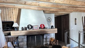 Un salon chaleureux avec une cheminée en pierre, des poutres apparentes, un canapé et une table basse.