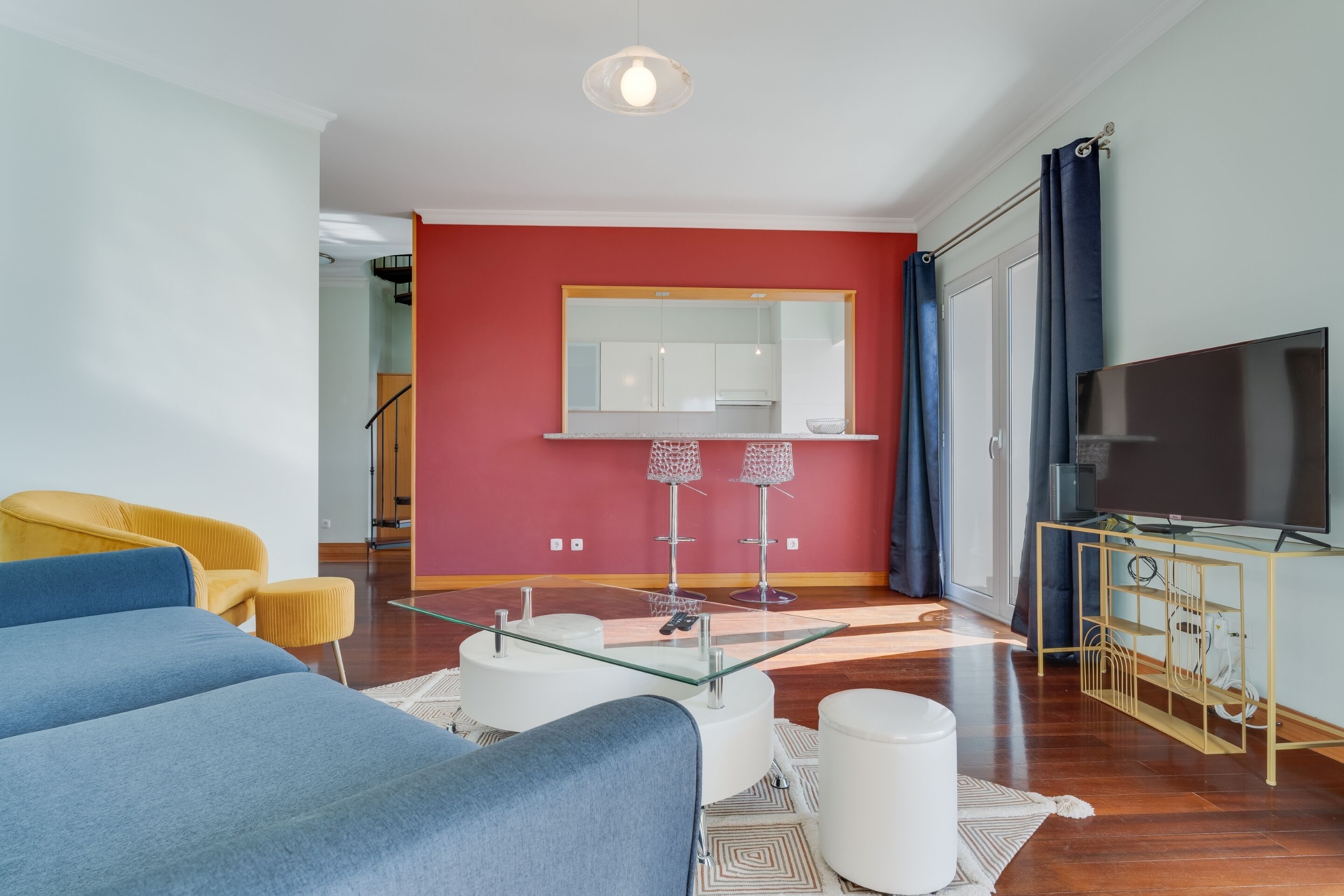 Ein modernes Wohnzimmer mit einer Couch, einem Glastisch und einem Fernseher.