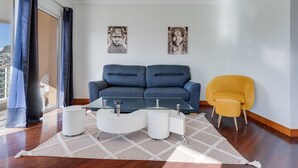 Un soggiorno moderno con un divano blu, una poltrona gialla e un tavolino in vetro.