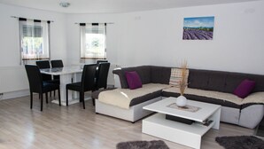 Una sala de estar moderna con sofá, mesa de centro y comedor.
