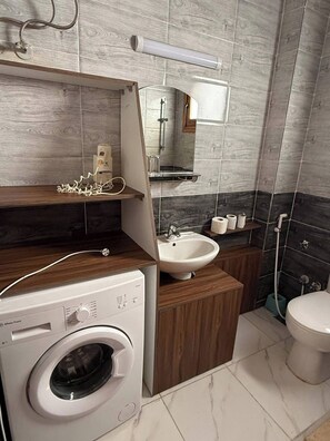 Een aparte badkuip en douche, een diep bad, handdoeken