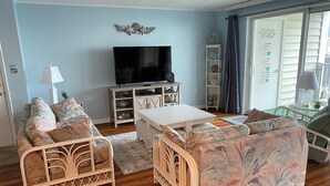 Un salon équipé d’un téléviseur, de deux canapés, d’une table basse et d’une bibliothèque.