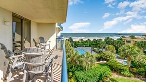 Un balcon avec mobilier d’extérieur, une piscine et une vue sur l’océan.