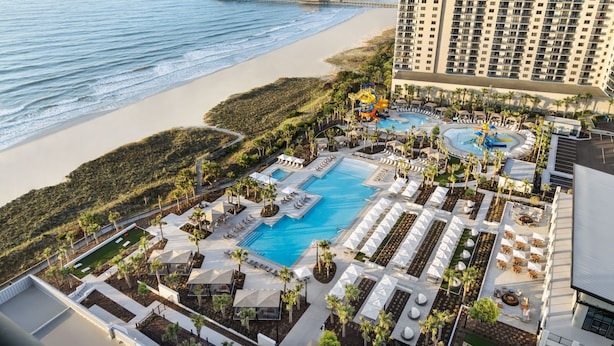 A resort with a large pool, sun loungers, and a beach view. - Updated 3 Bedroom Bathroom Villa, 13D Richmond Park Villa (Myrtle Beach)