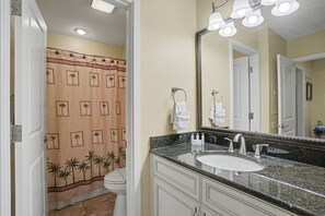 A bathroom with a sink, mirror, and towel rack.