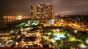 A resort with a large pool, multiple buildings, and a beachfront view.