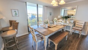 A dining area with a wooden table, chairs, and a view of the outdoors.