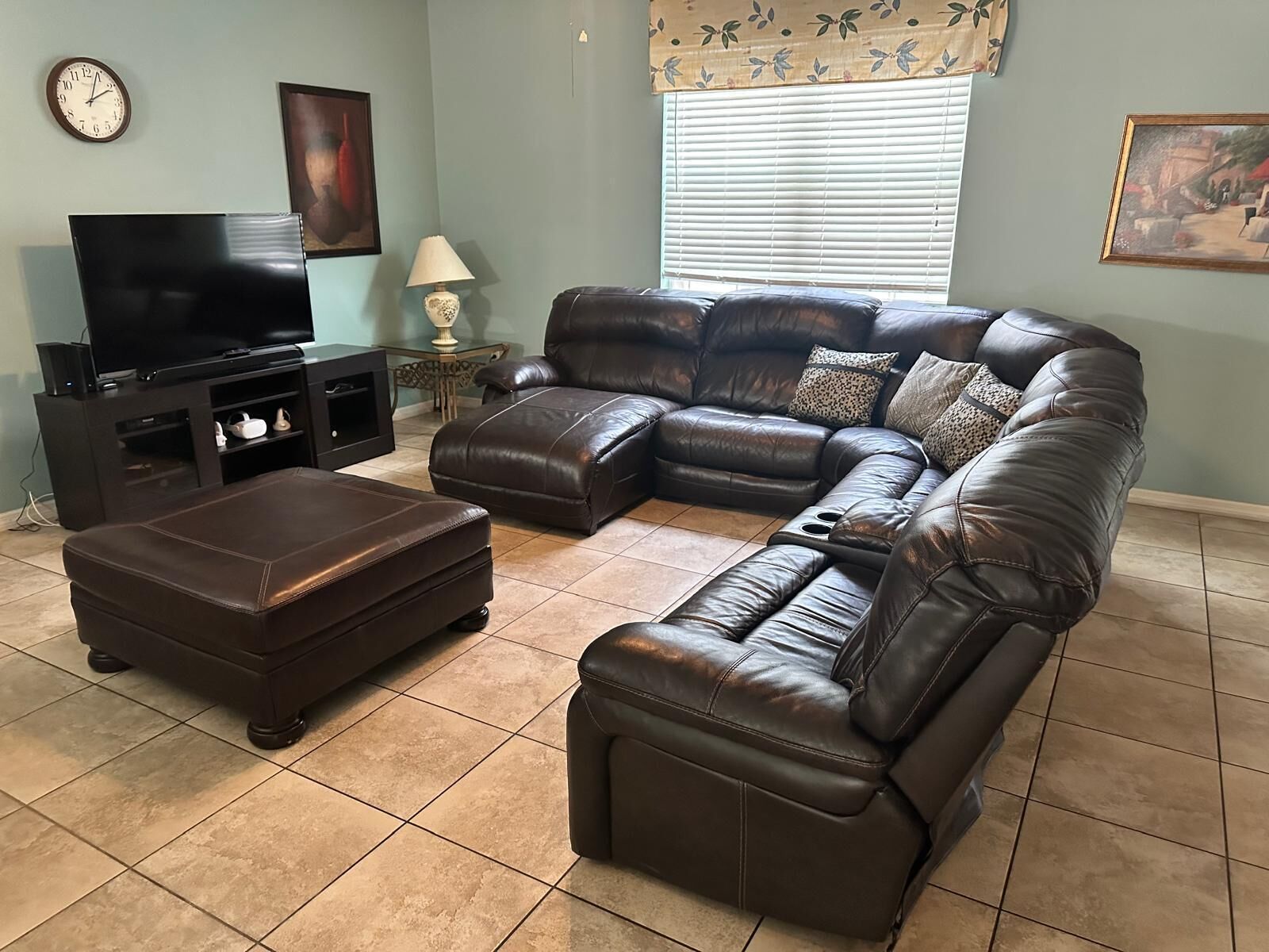 A living room with a sectional sofa, a TV, and a lamp.