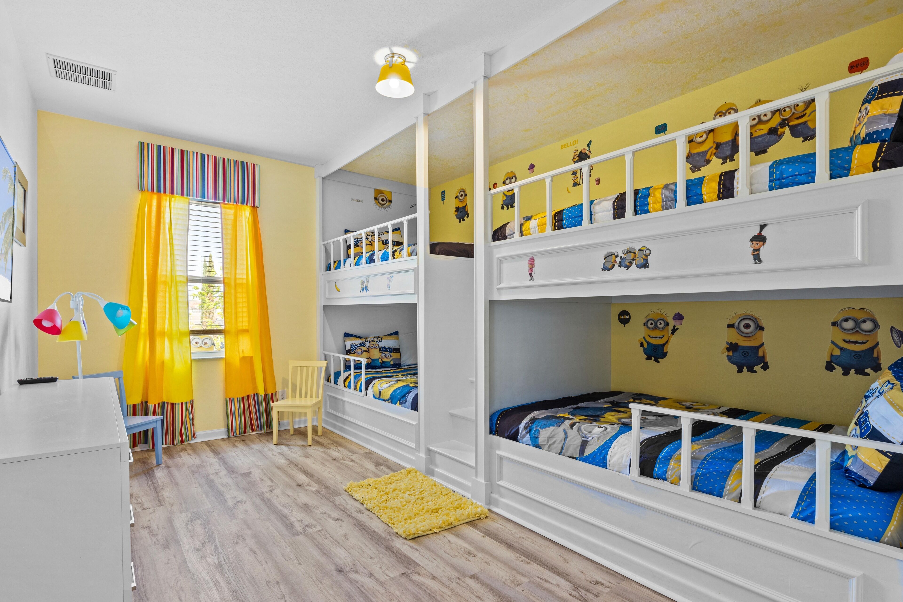 Una habitación infantil con literas, un escritorio y una silla.
