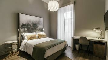 A modern bedroom with a large bed, a desk, and a chair.