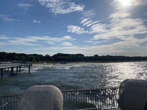 Eine Steg, der sich über ein Gewässer erstreckt, mit blauem Himmel darüber.