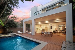 Alberca al aire libre y camastros 