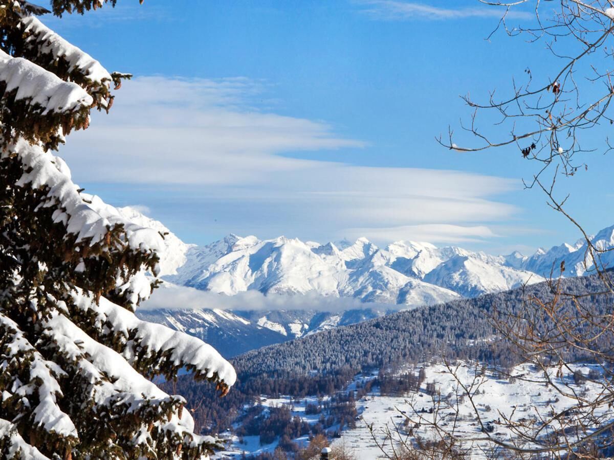 Un paysage montagneux enneigé sous un ciel dégagé.