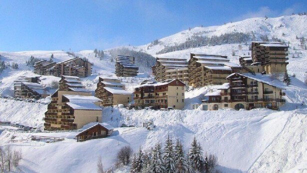 A snow-covered mountain resort with multiple chalet-style buildings, each with balconies and a rustic appearance. - At the foot of shops, 2nd floor, view panoramic, balcony, tv, ski locker, 55m², Auris en Oisans (Auris)