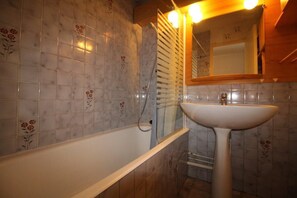 Un baño con bañera, lavamanos y espejo.