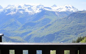 A mountain landscape with snow-capped peaks and lush green valleys.