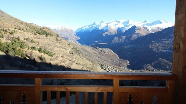 A mountain landscape with snow-capped peaks and a valley below.