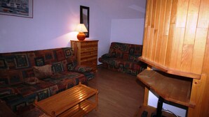 A living room with two sofas, a wooden coffee table, a lamp, and a wooden cabinet.