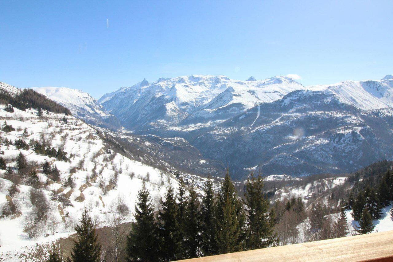 A mountainous landscape with snow-covered peaks and a valley.