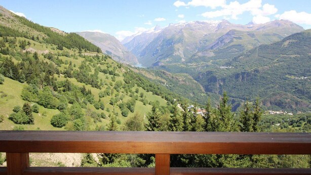 Un paysage montagneux avec une vallée et un lac.