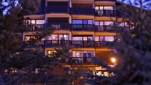 Un hotel de varios pisos con balcones, un cartel que dice 'Les Martagons' y un restaurante visible.