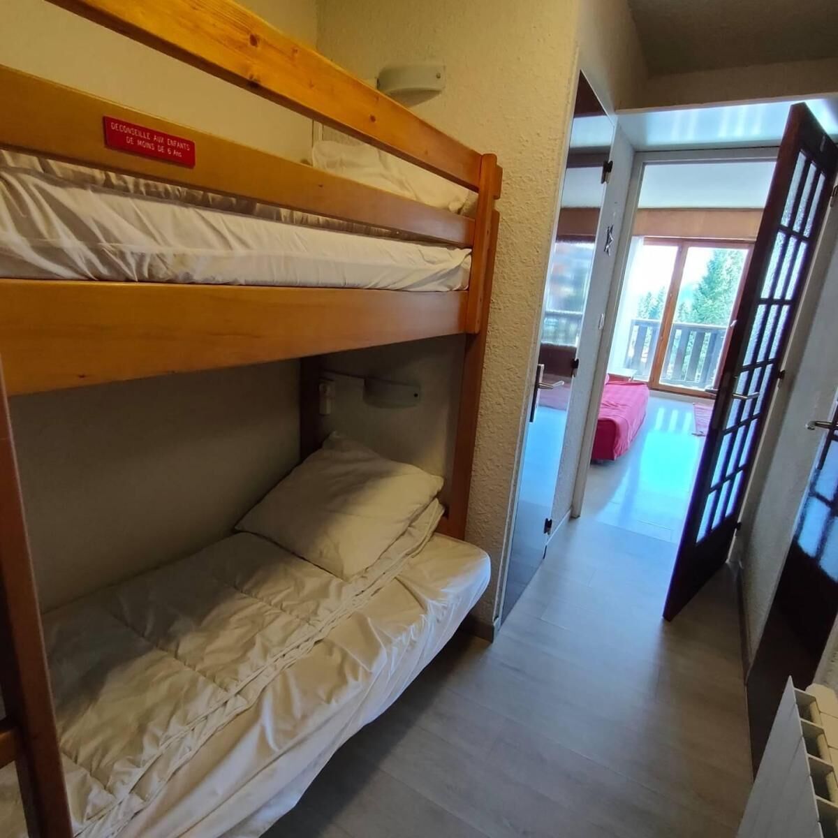 Habitación con literas y un cartel que indica que es para niños menores de 6 años.