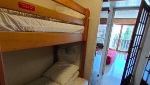 Une chambre avec des lits superposés, sur laquelle est apposée une pancarte indiquant qu’elle est réservée aux enfants de moins de 6 ans.