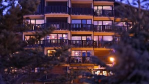 Un hôtel à plusieurs étages doté de balcons, une enseigne indiquant « Les Martagons », et un restaurant bien visible.