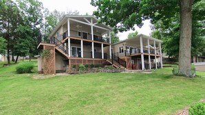 A two-story house with a covered porch and a staircase leading to the upper level. - JOMO Tri Terrace - Units 2 & 3 (Rocky Mount)