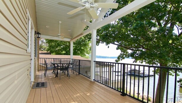 A covered deck with a table and chairs, overlooking a body of water. - JOMO Tri Terrace - Units 2 & 3 (Rocky Mount)