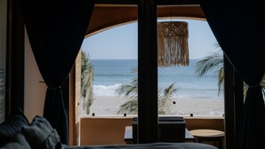 Un dormitorio con vista a la playa, techo de madera y una lámpara colgante.