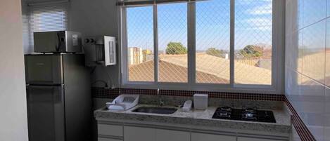 Una cocina moderna con encimera de granito, electrodomésticos de acero inoxidable y un amplio ventanal con vistas al exterior.
