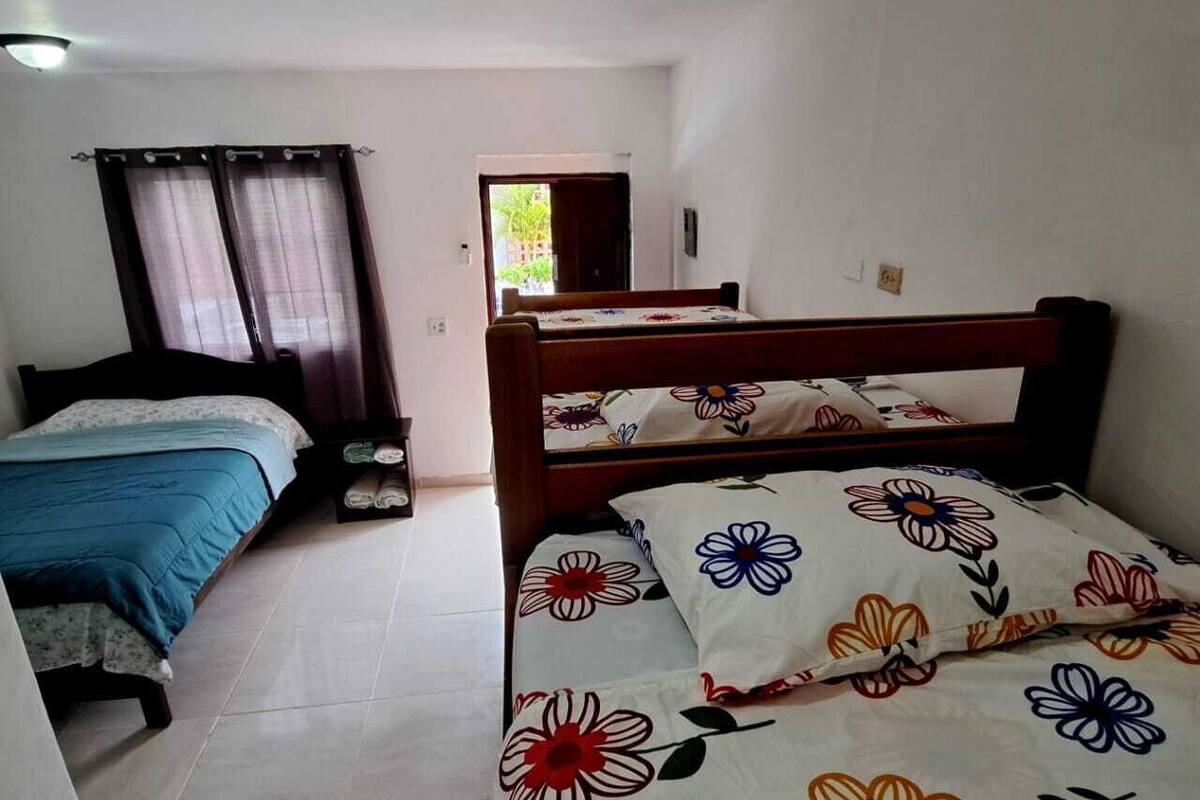 Une chambre avec deux lits, l’un recouvert d’une couvre-lit à motifs floraux et l’autre d’une couvre-lit bleue.