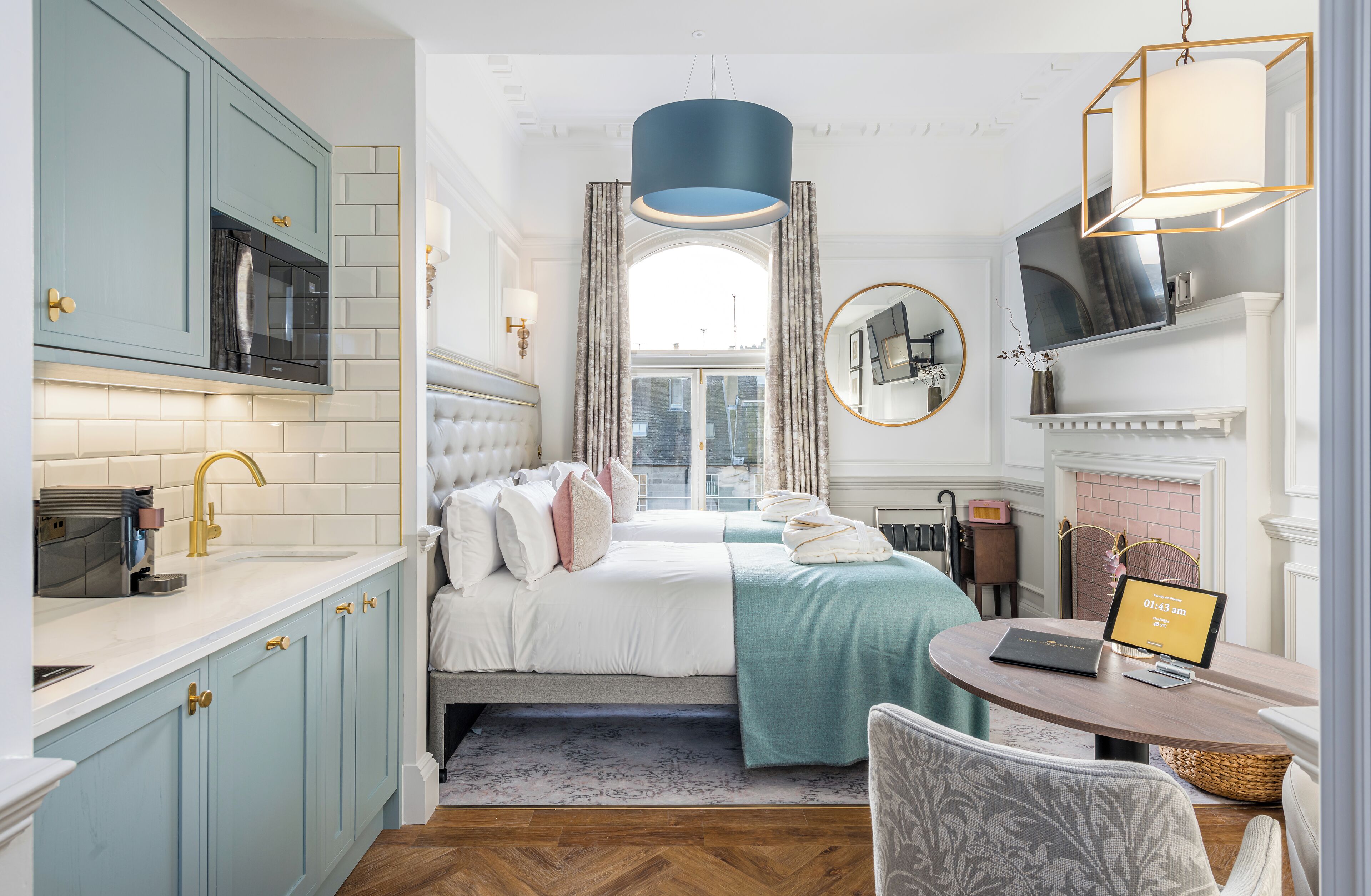 A bedroom with a bed, bedside table, and a view of the city.
