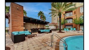 An outdoor pool area with lounge chairs and a bar area. - Universal-Disney Dream 2 Bedroom (Orlando)