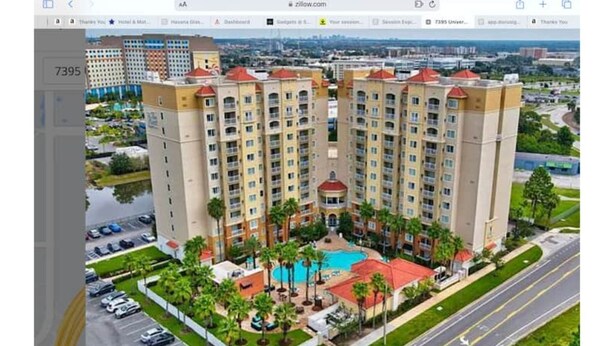 A high-rise hotel with multiple balconies, a swimming pool, and a landscaped courtyard. - Universal-Disney Dream 2 Bedroom (Orlando)