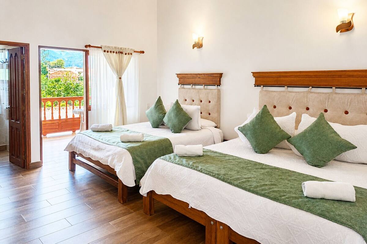 Ein Hotelzimmer mit zwei Betten, einem Balkon und Blick sowie einem Holzboden.