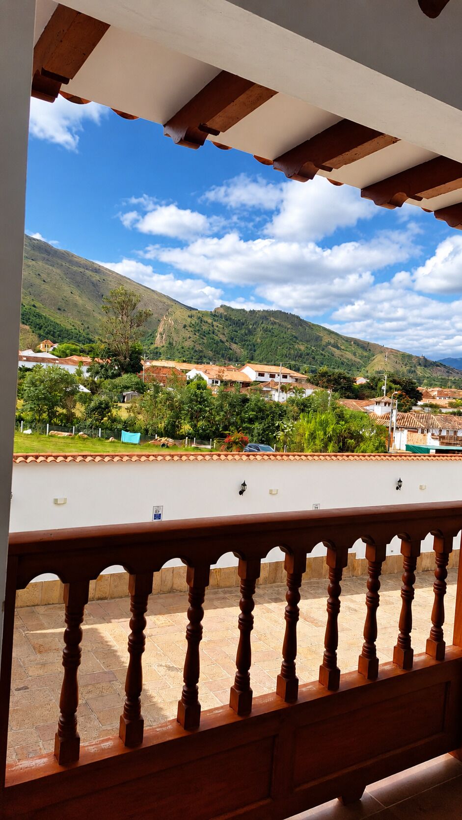 A balcony with a view of a town and mountains.