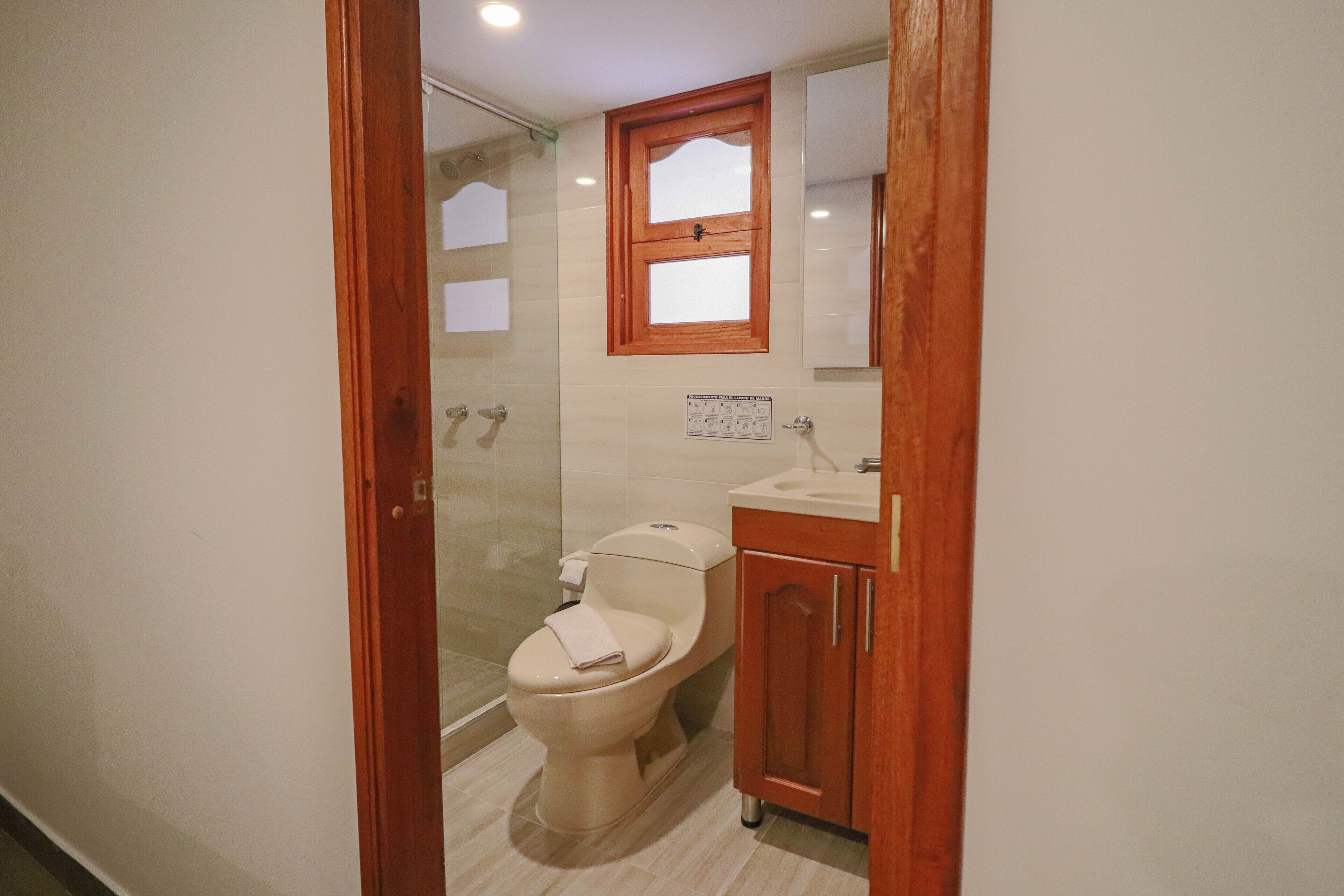 A bathroom with a toilet, a sink, and a mirror.